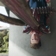 Doctor Octopus's robotic tentacle pins the unmasked Spider-Man's body to a concrete pillar.